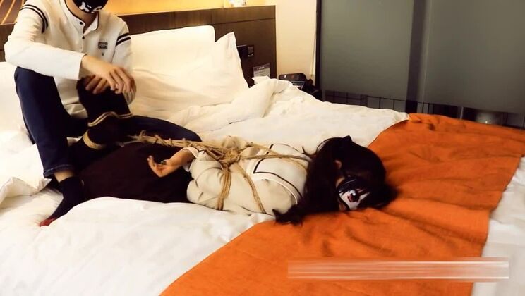 Une fille à couettes est ligotée et bâillonnée.